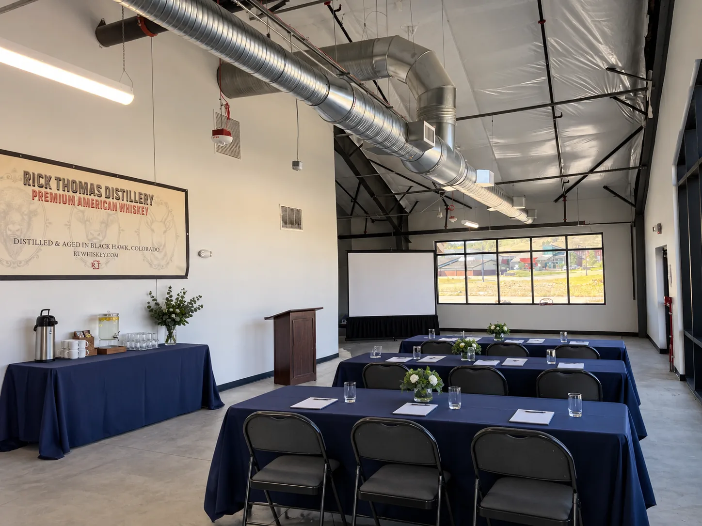 Event room arranged with rows of tables and chairs for a meeting